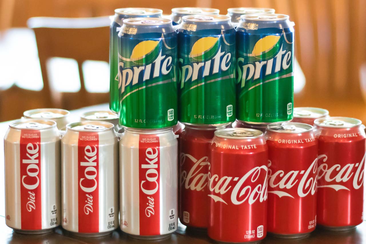 Three six packs of canned coca-cola products including coke, diet coke, and sprite