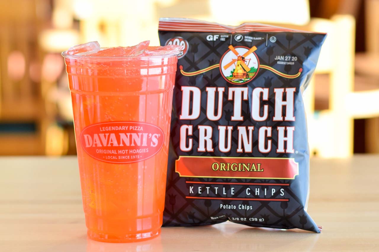 Regular sized orange fountain drink and a bag of old dutch crunch original kettle chips. 