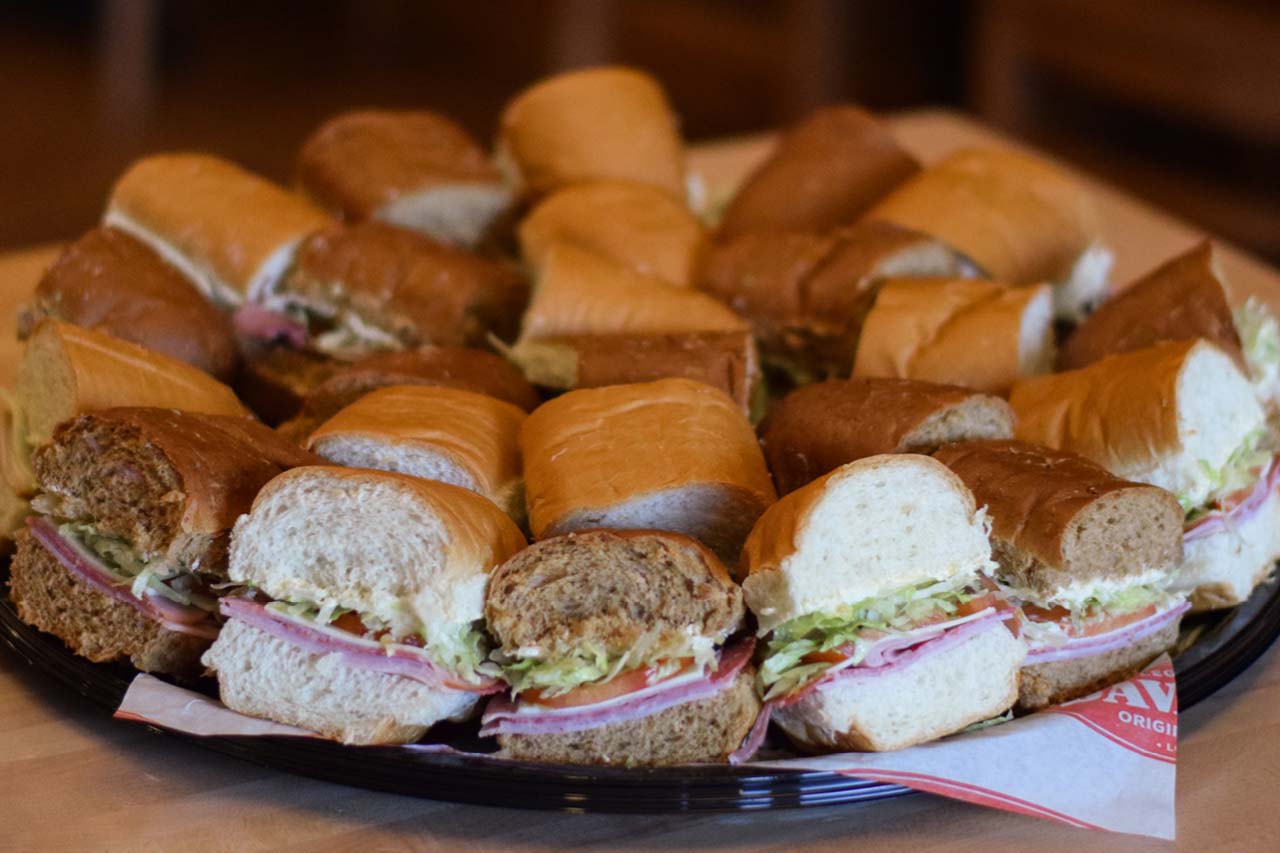 Assortment of quartered hoagies served cold on a platter.